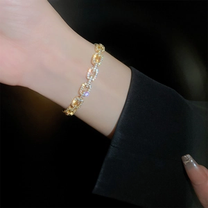 Close-up of gold plated chain bracelet with sparkling zircon stones on female wrist