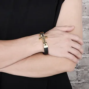 Close-up of a men's braided black leather bracelet featuring a golden metal cross clasp