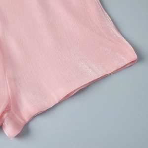 Macro detail of light pink chiffon fabric with vertical pleated texture and pearl luster