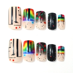 Detail of square press-on nails featuring rainbow gradients and black starry patterns