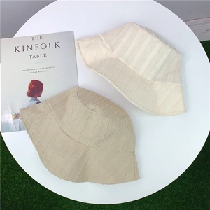 Détail à plat de chapeaux bobs rayés en beige et kaki avec une texture respirante
