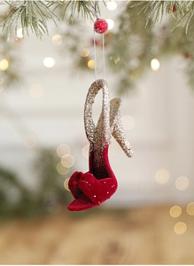 Detail of red velvet high heel Christmas ornament with gold glitter on pine branch