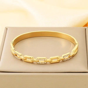 Detailed view of a gold chain bracelet with sparkling rhinestones on luxury silk display