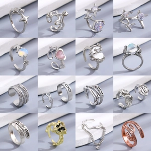 Set of 16 assorted fashion rings including stars, hearts, and gems on a gray background