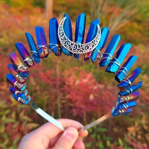 Macro shot of blue aura quartz crystals and silver crescent moon on a metal headband