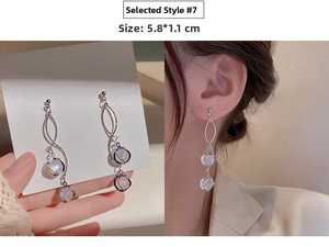 Detail view of long silver tassel earrings with purple stones measuring 5.8 by 1.1 cm