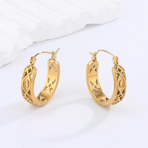 Detail of vintage gold-finished hollow pattern on stainless steel hoop earrings