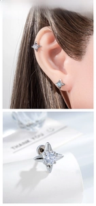 Macro detail of four-pointed star stud earring with blue zircon and silver metal finish