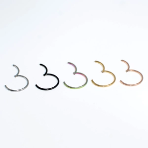 Detailed view of five multi-color hinged segment rings in silver gold and black finishes