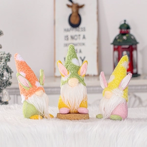 Three Easter gnome dolls with rabbit ears and white beards on a soft white blanket