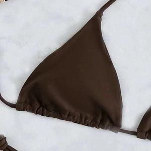 Close-up of deep brown triangle bikini top with pleated edges and tie-up strap details