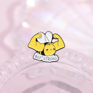 Starke Biene Emaille-Anstecknadel mit Bee Strong Text und weißer Wolke auf lila Hintergrund