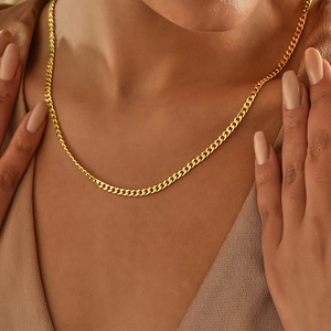Detailed close-up of 14k gold plated cuban link chain necklace on model's neck