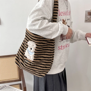 Close-up of plush striped tote bag featuring a cute white cartoon dog patch and texture