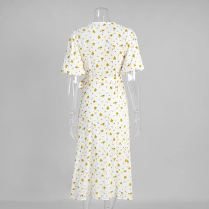 Detail of white cotton floral midi dress showing puff sleeves and wrap waist tie