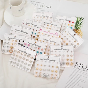 Fashion earring sets collection featuring acrylic, pearl, and metallic studs on display cards