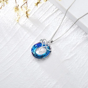 Macro view of blue crystal pendant with silver knot and sparkling zircon detail