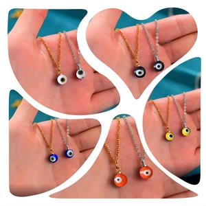 Detail view showing multi-colored evil eye charms in gold and silver stainless steel chains