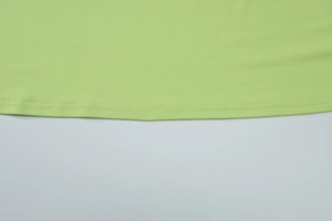 Vue détaillée de l'ourlet et de la texture du tissu sur une robe verte dos nu