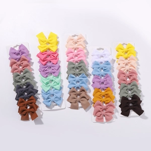 Set of 10 colorful waffle fabric bow hair clips for kids on white display cards