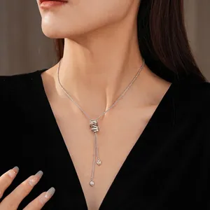 Silver zircon circle pendant necklace with long tassel heart charms on a female model