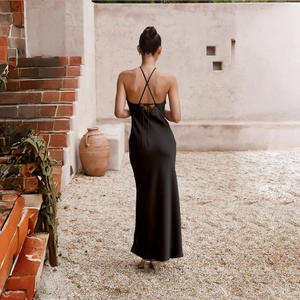 Detail of cross-tie straps on the back of a black satin backless slim-fit maxi dress