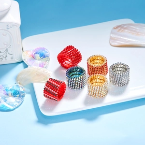 Macro detail of multi-row rhinestone elastic rings in various colors on a ceramic tray