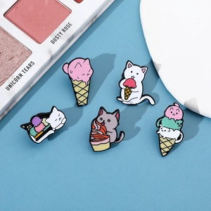 Detailed close-up of colorful cat ice cream cone enamel pins on a soft blue background