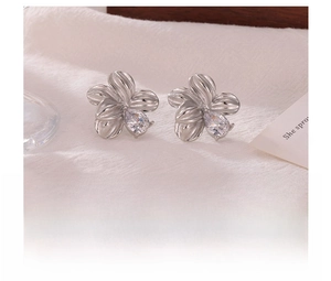 Detailed view of silver titanium steel flower stud earrings with center zircon stone