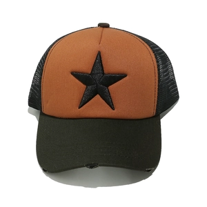Detail of distressed brim and 3D star embroidery on orange and green mesh trucker hat