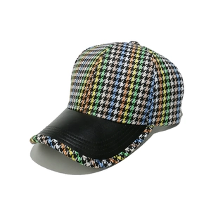 Detailed close-up of a colorful houndstooth baseball cap with a black leather brim detail
