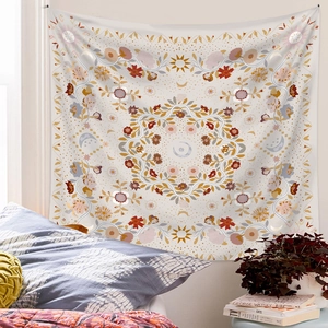 Bohemian mandala tapestry with sun and moon motifs hanging in a cozy bedroom setting