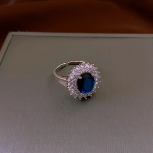 Dettaglio anello in zircone blu ovale con cristalli bianchi pavé su fascia regolabile