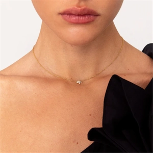 Close-up of golden marquise-shaped floral pendant necklace worn on a woman's collarbone