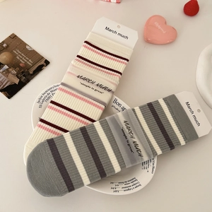 Striped mid-calf cotton socks in vintage cream and grey, set on a chic porcelain plate