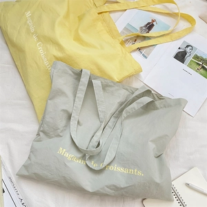 Detail view of large canvas tote bags with French print and minimalist soft texture