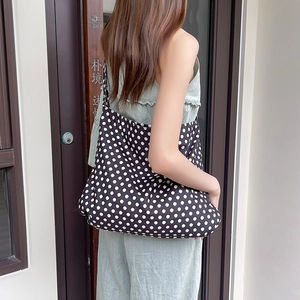 Detailed view of the large capacity black and white polka dot canvas shoulder bag