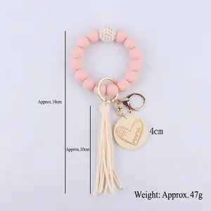 Pink silicone beaded bracelet keychain with mama wood charm and cream tassel