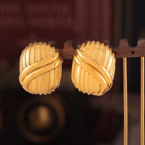 Vintage gold-plated multi-layer geometric earrings on a wooden display stand