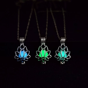 Detailed view of luminous lotus pendants glowing in blue and green in dark environment