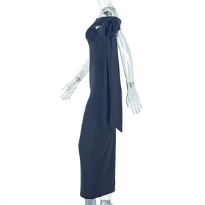 Détail d'une robe noire élégante à épaules dénudées avec un grand nœud et des rubans