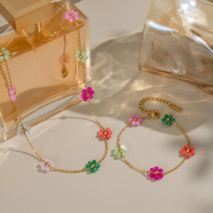 Detailed macro view of colorful floral beads on a gold stainless steel necklace set