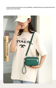 Detail of dark green nylon crossbody bag with zipper compartments and adjustable strap