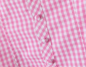 Close-up of pink gingham fabric with matching fabric-covered buttons on the shirt
