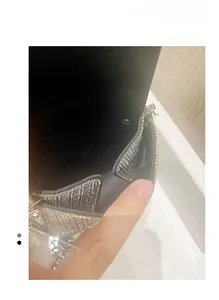 Close-up of a silver rhinestone mini bag with black lining and metal chain strap