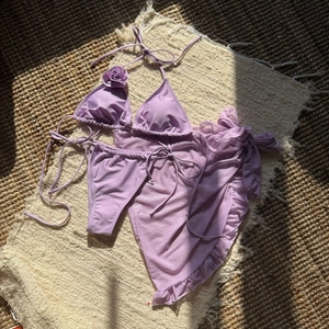Detailed view of lavender purple bikini set with 3D rose decoration and mesh skirt