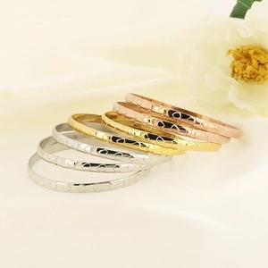 Set of 5 minimalist heart pattern bangles in gold, silver, and rose gold on silk