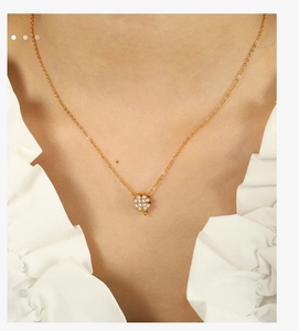 Detailaufnahme einer goldenen vierblättrigen Kleeblatt-Halskette mit Zirkonia am Model
