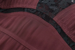 Detailed view of burgundy ribbed fabric with delicate black floral lace stitching