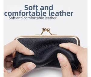 Detail shot showing the soft texture and gold clasp of the black leather mini coin purse